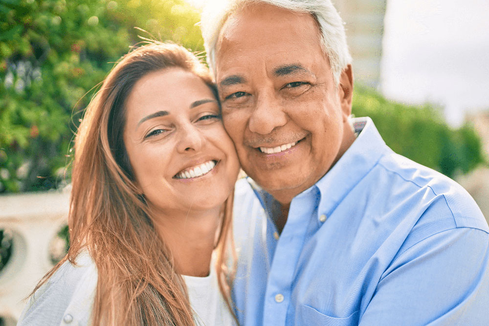 Happy couple with bright smiles, showcasing results of cosmetic dentistry
