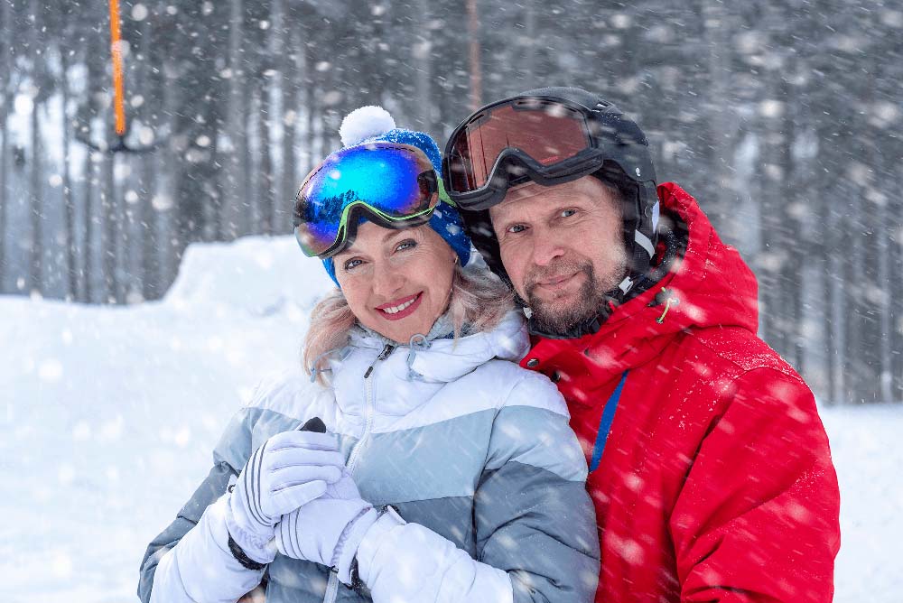Happy couple in winter gear smiling, representing healthy smiles with Crowns in Jackson Hole, WY