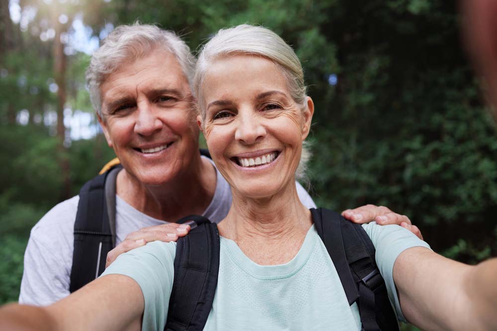 Active couple with bright smiles, highlighting Dental Implants benefits
