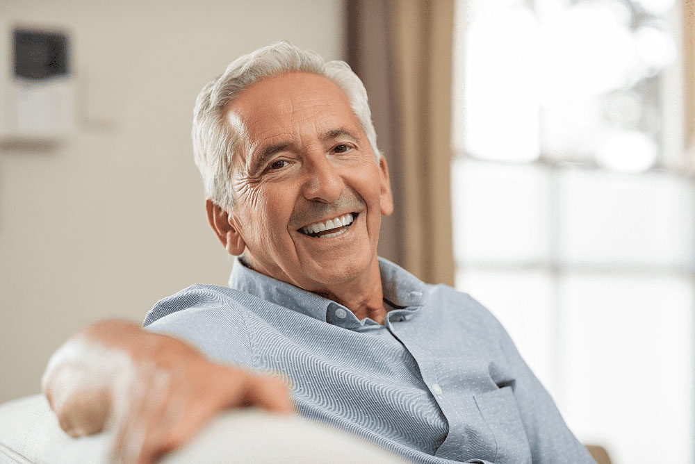 Smiling senior man at home, representing comfortable Dental Implants and lasting dental results