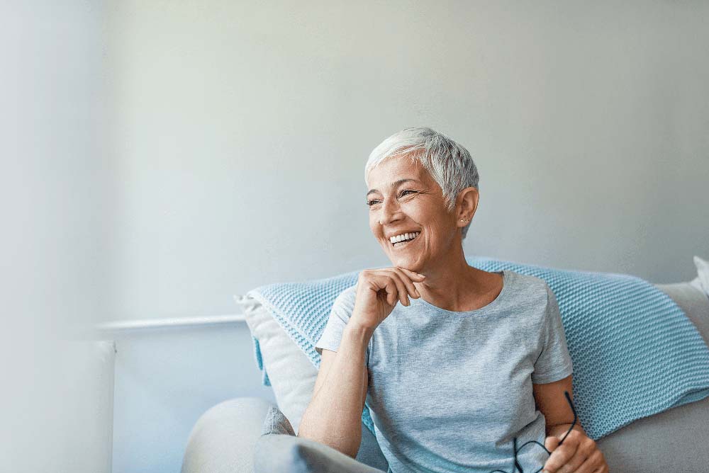 Relaxed woman smiling, representing long-term oral health and Full-Arch Replacement