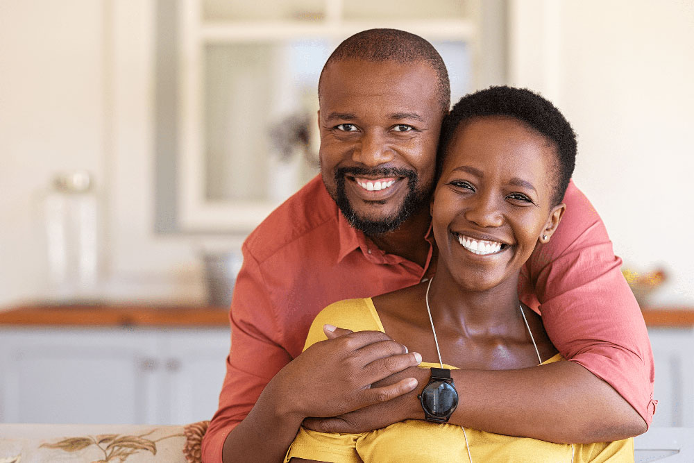 Happy couple smiling, representing results of general and preventive dentistry