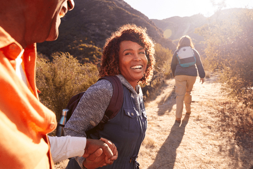 Active woman hiking with confident smile, representing healthy lifestyle and dental care