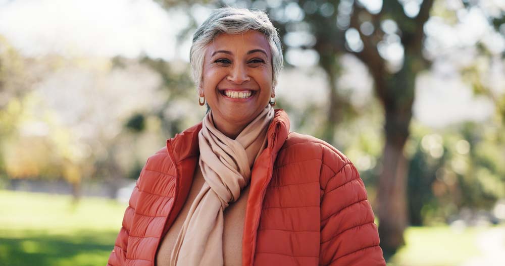 Smiling woman outdoors with healthy teeth, showcasing Periodontal Scaling & Root Planing