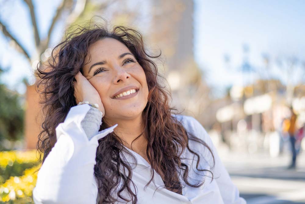 Smiling woman outdoors showing healthy teeth after dental care in Jackson, WY