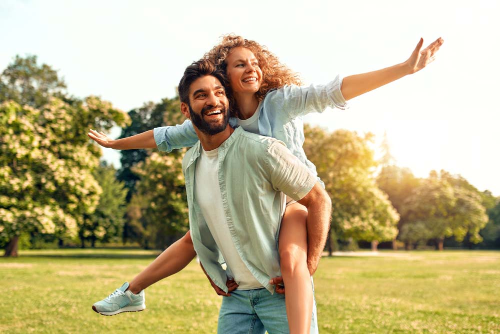 Happy couple enjoying outdoors with confident smiles after Sedation Dentistry