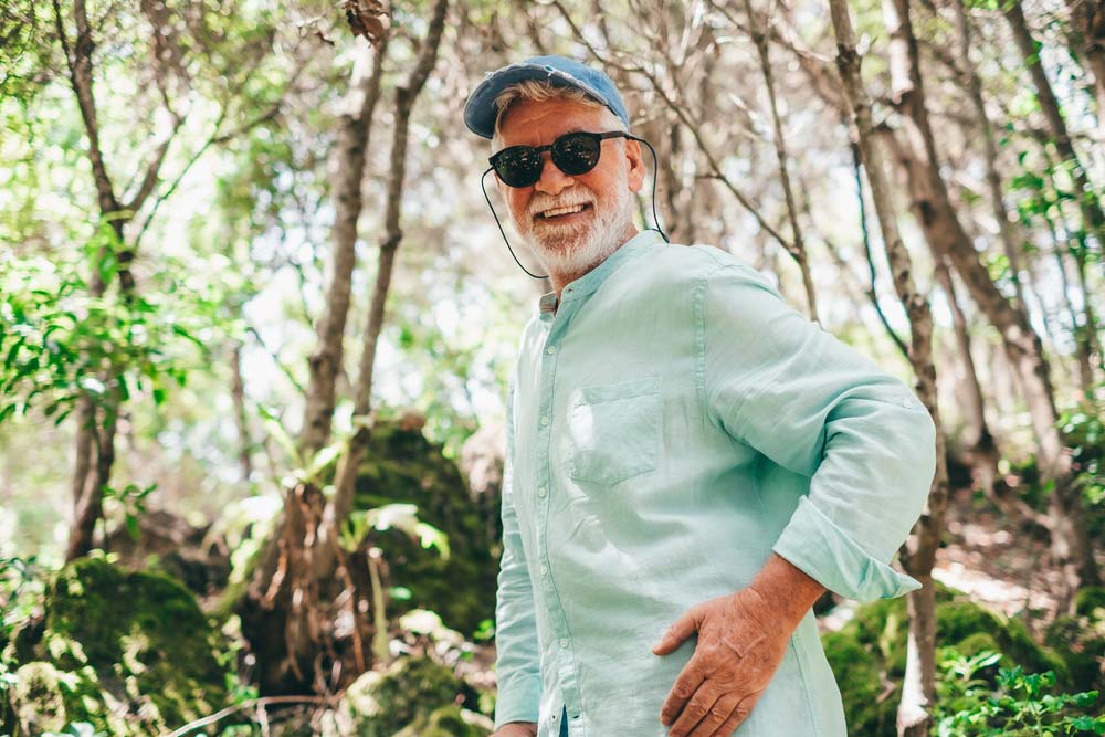 Active man hiking with confident smile, showing good results after Tooth Extraction