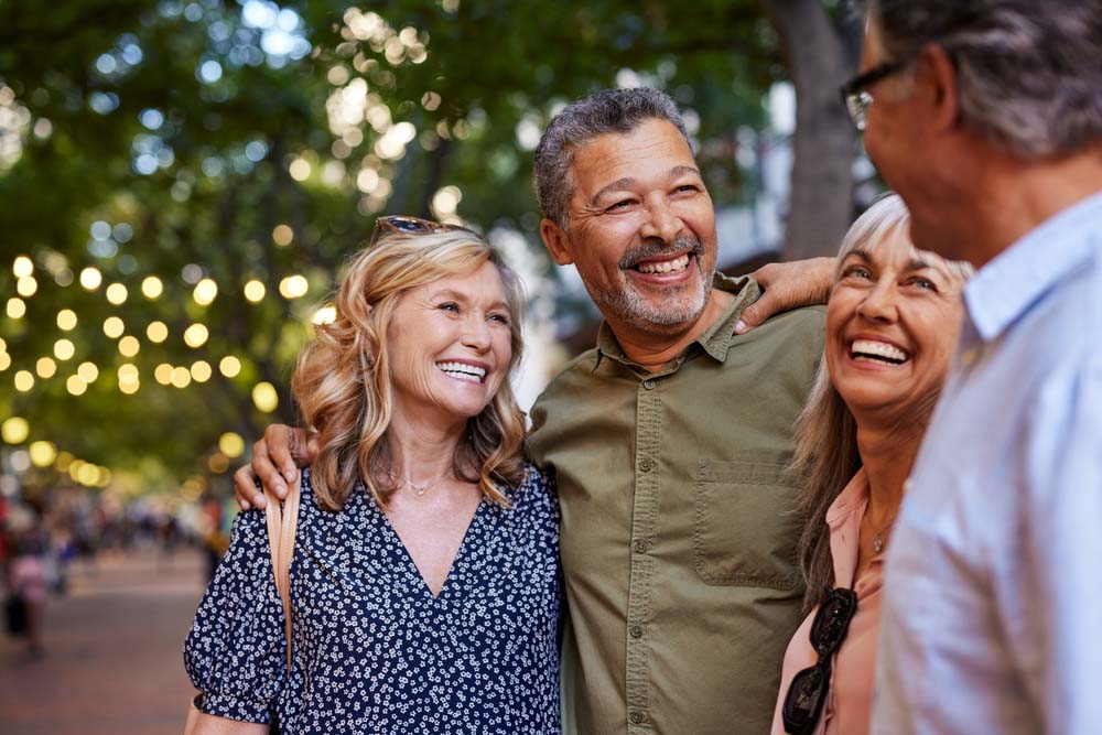 Happy group of adults smiling together, showcasing confident smiles after Single Tooth Replacement