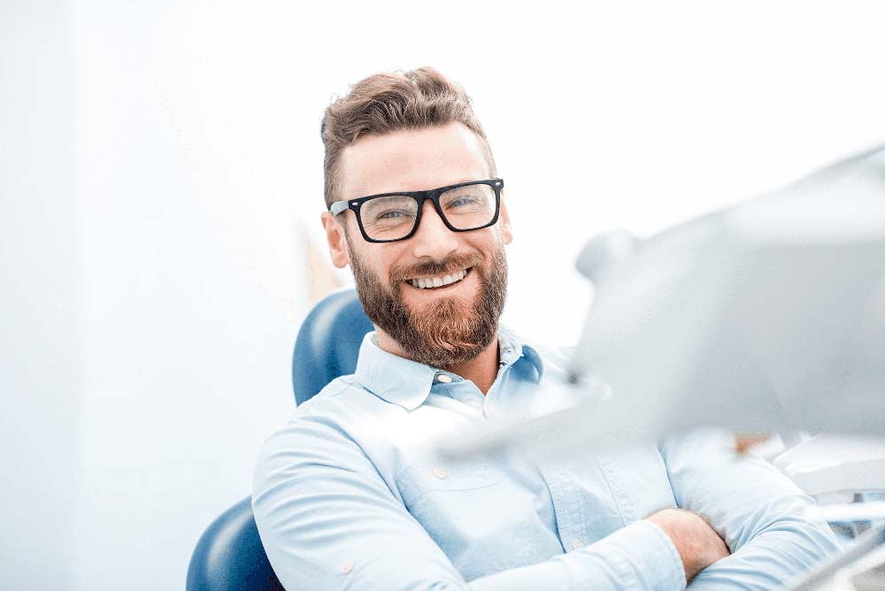 Smiling patient in dental chair, highlighting comfortable dental care experience