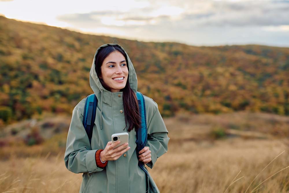 Young woman hiking with a bright smile, representing healthy lifestyle and Porcelain Veneers